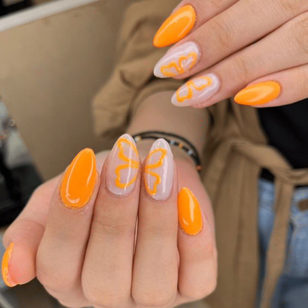 Close up of nails with glittery orange nails having Spring Orange Butterfly Nails