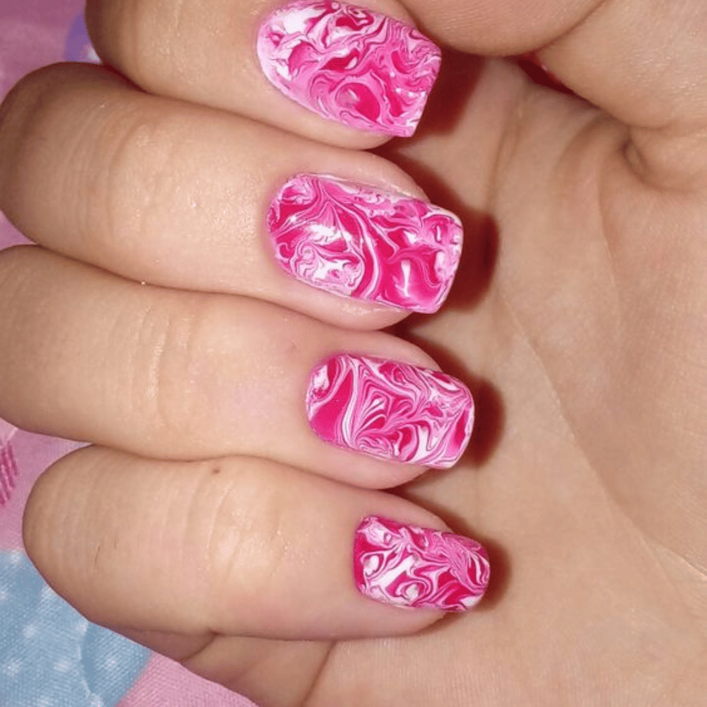 Hand with Pink Nails having Pink and White Swirled Design