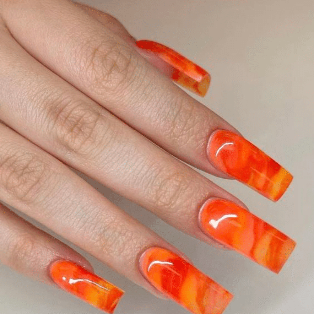 Close up of nails with glittery orange nails having Orange Marble Effect