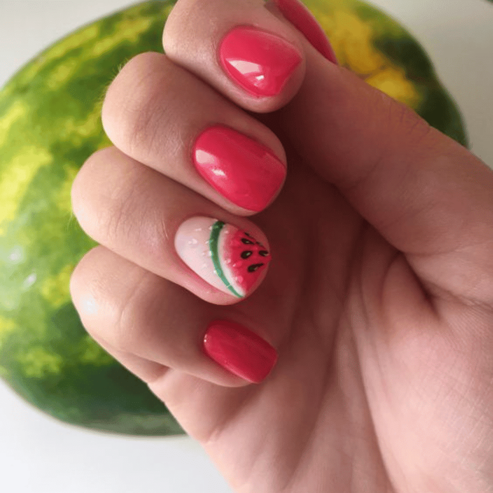 A person displays a watermelon adorned with a creative nail design, showcasing a unique blend of nature and artistry.