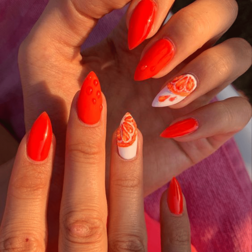 Close up of nails with glittery orange nails having Water Decals for Orange Designs