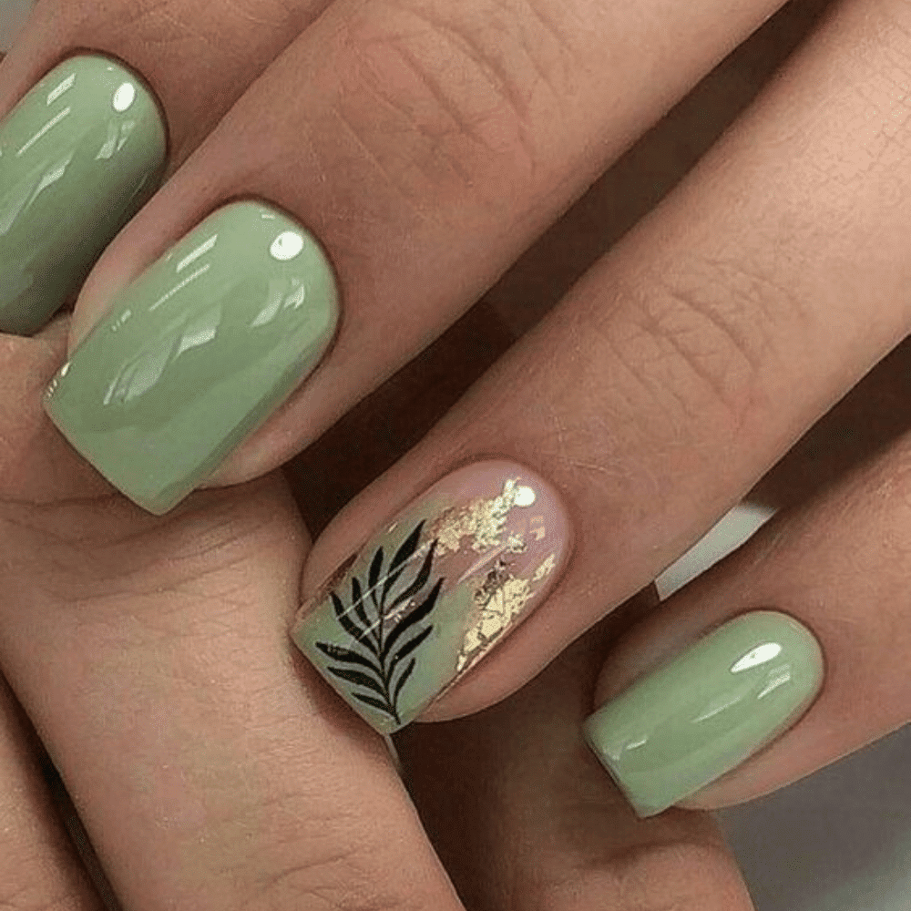 Green nail polish featuring an elegant gold leaf design, showcasing a stylish and sophisticated manicure.