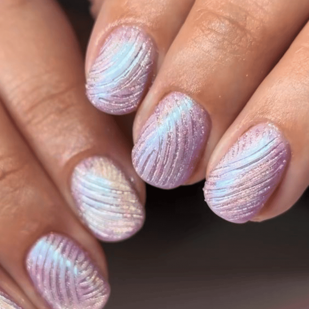 A close-up of a woman's hand showcasing a stylish purple and white manicure, highlighting the elegant nail design.