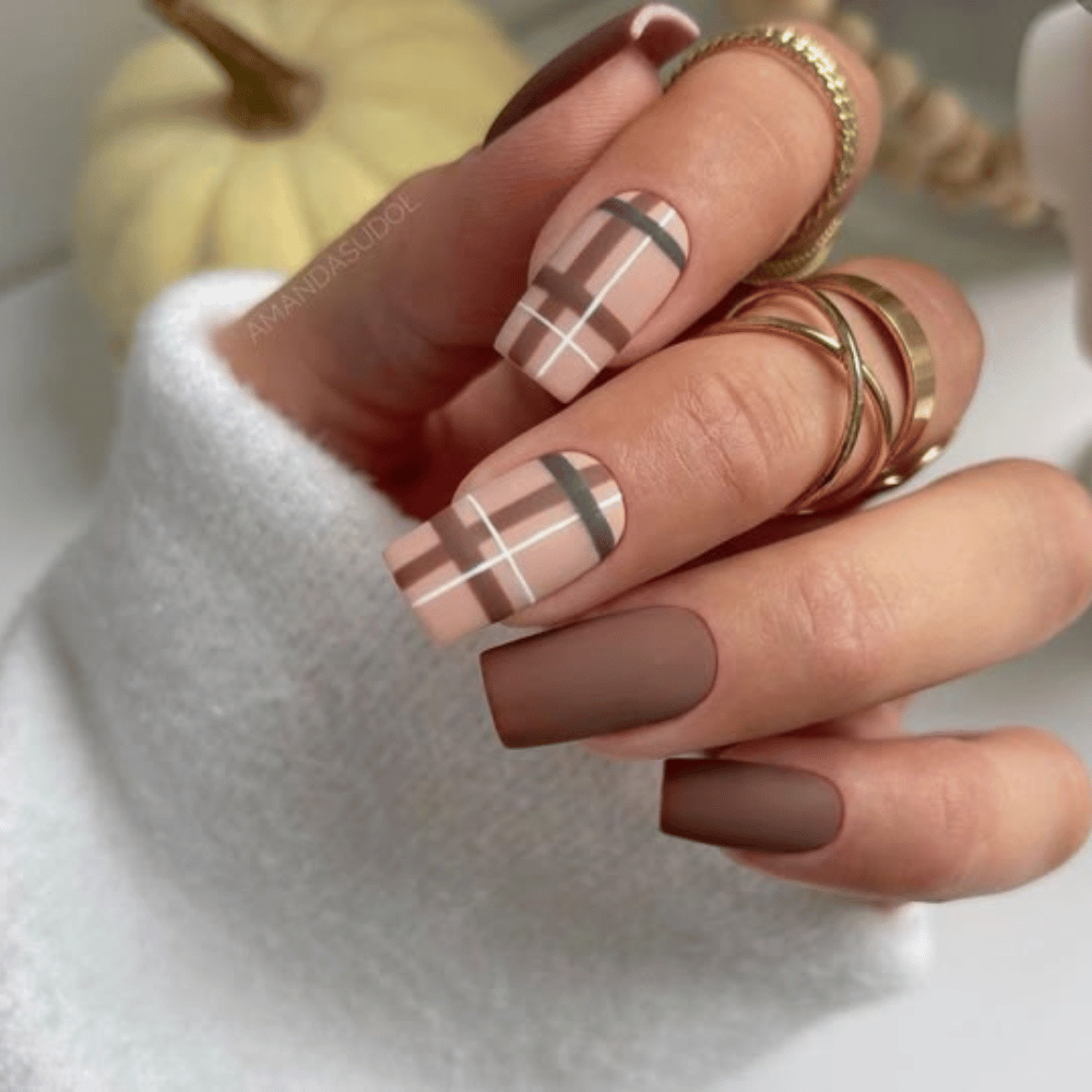 Close-up of hands with fall nail design having Geometric Patterns in Fall Colors