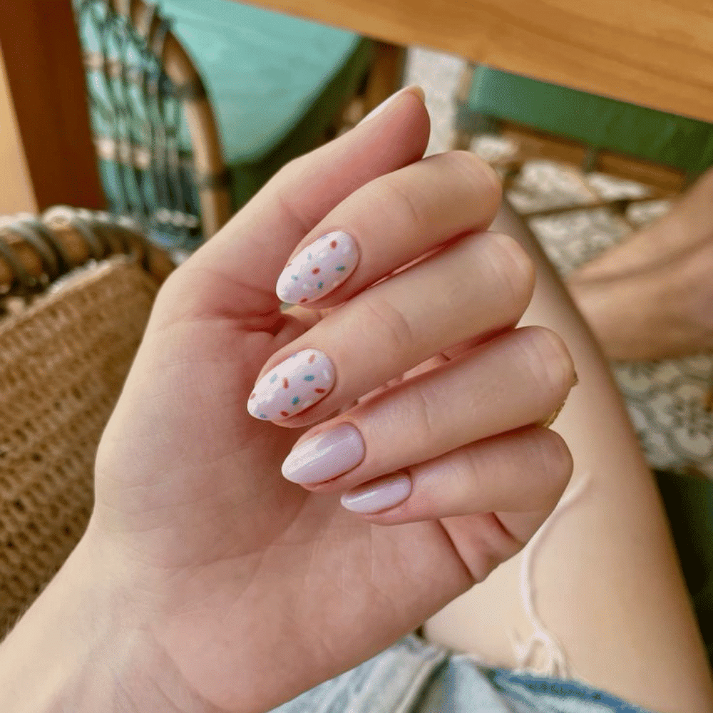 A person showcasing a white and pink manicure, highlighting the elegant nail design and polished appearance.