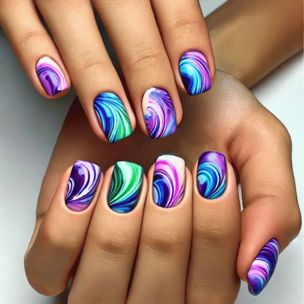 A close-up of a woman's hands adorned with intricate purple and blue swirl designs on her nails.