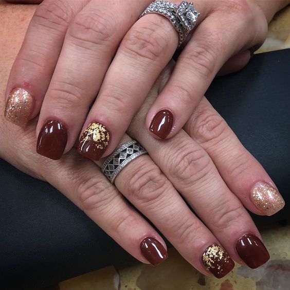 Close-up of hands with fall nail design having Gold Leaf Applications