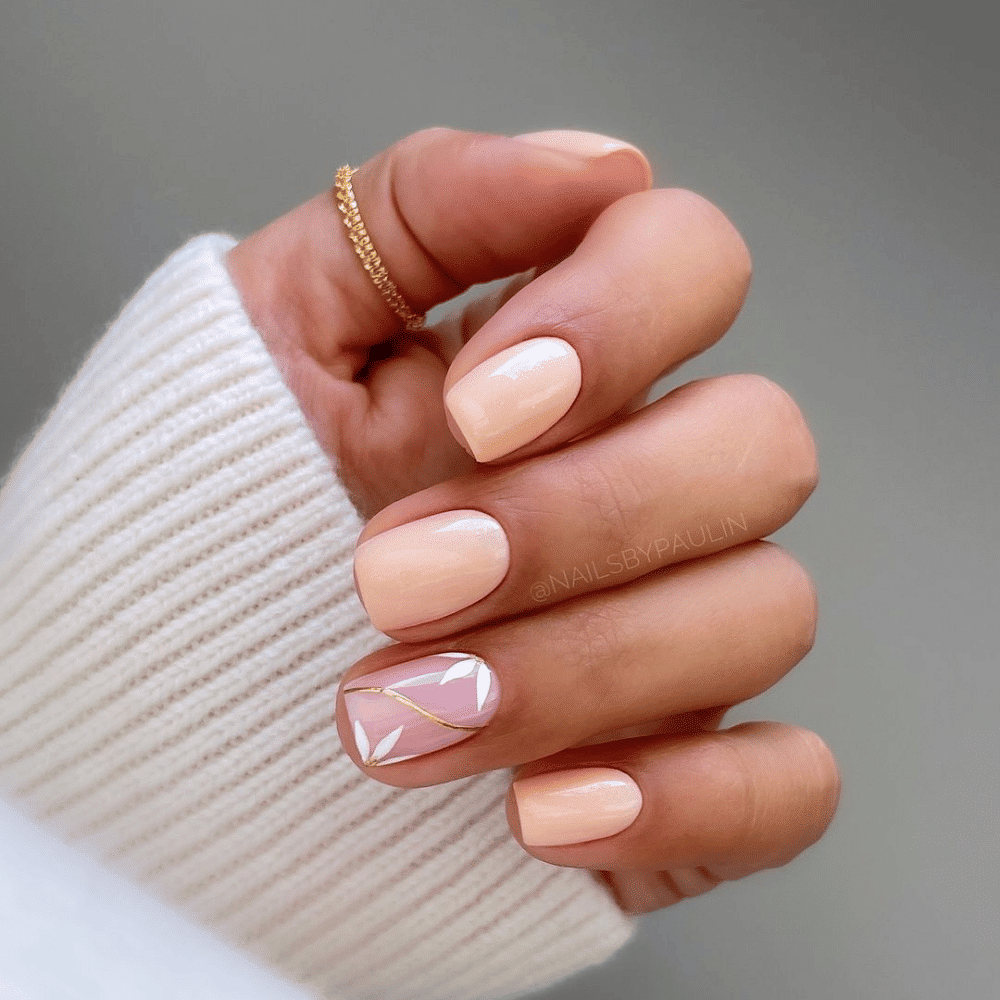 A close-up of a woman's hand showcasing elegantly manicured pink and white nails against a neutral background.