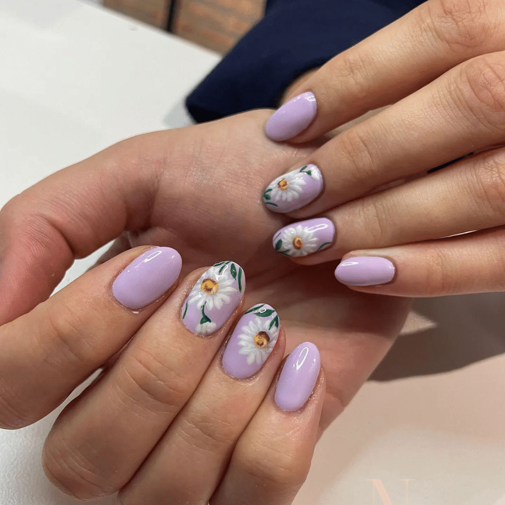 Close-up of hands with white nails featuring metallic rose gold designs and white polka dots