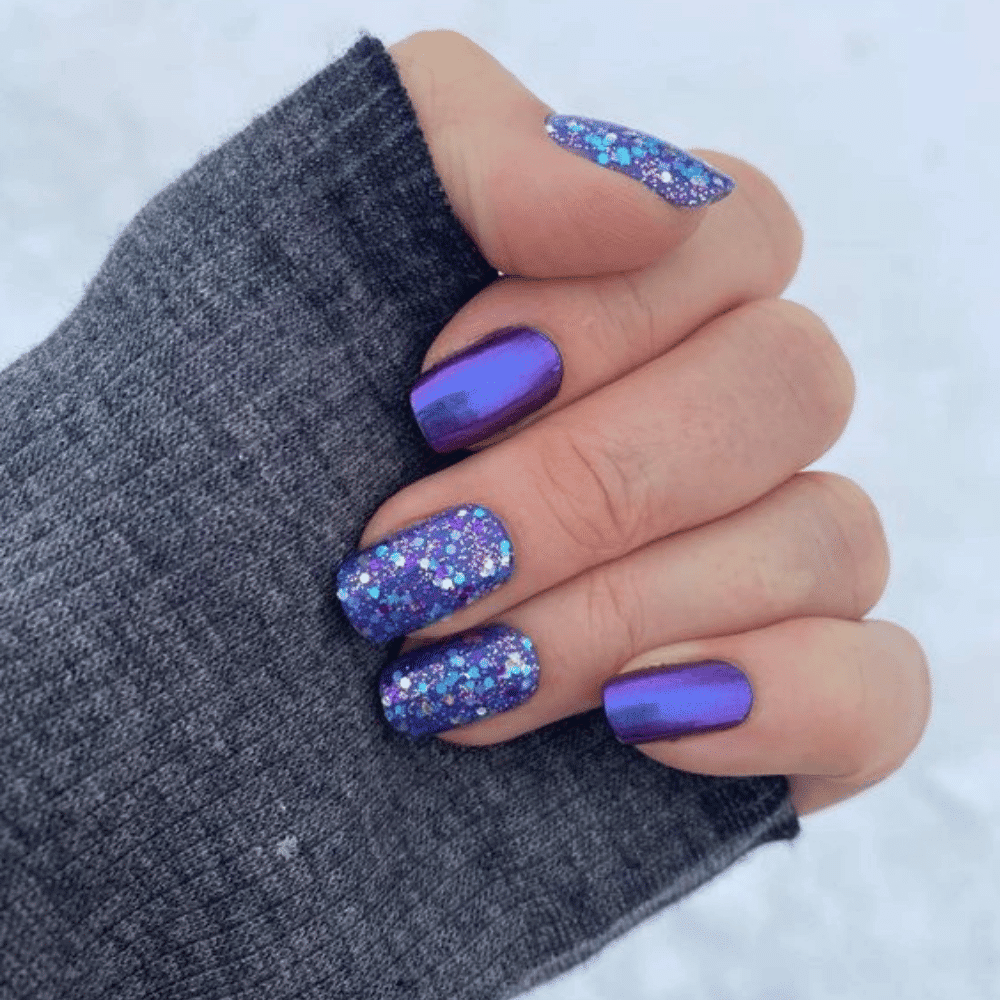 A close-up of purple glitter nail polish in a bottle, showcasing its shimmering texture and vibrant color.