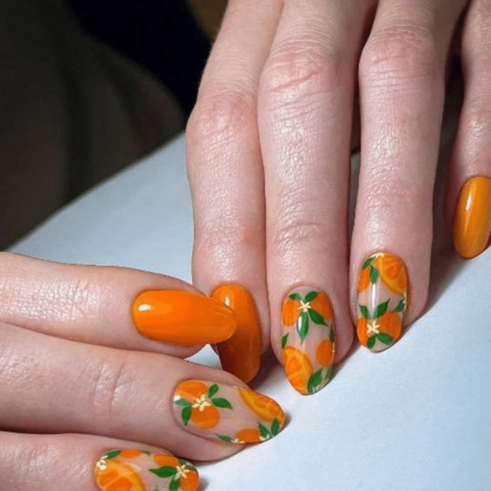 Close up of nails with glittery orange nails having Orange Blossom Nail Art