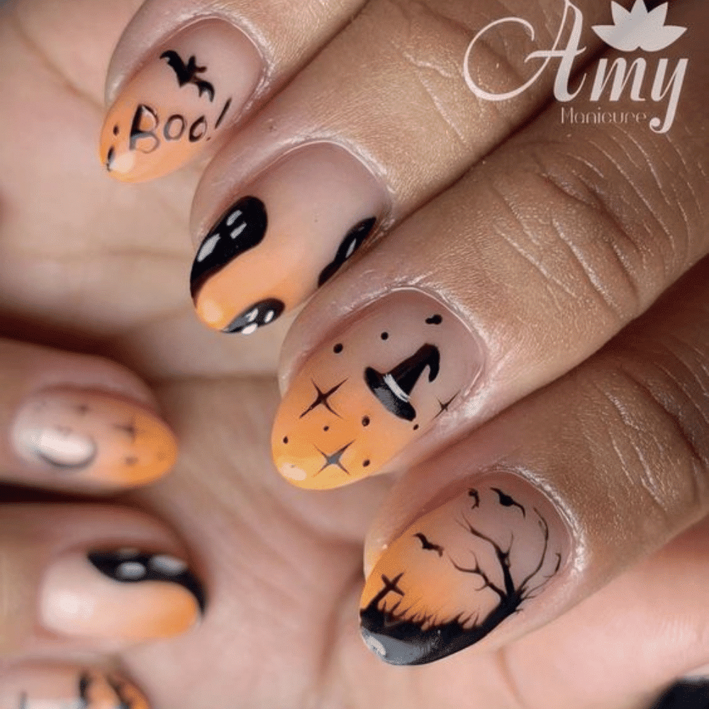 Close-up of a hand with Halloween-themed nail art. Nails are painted with orange and black gradient, featuring intricate designs of bats