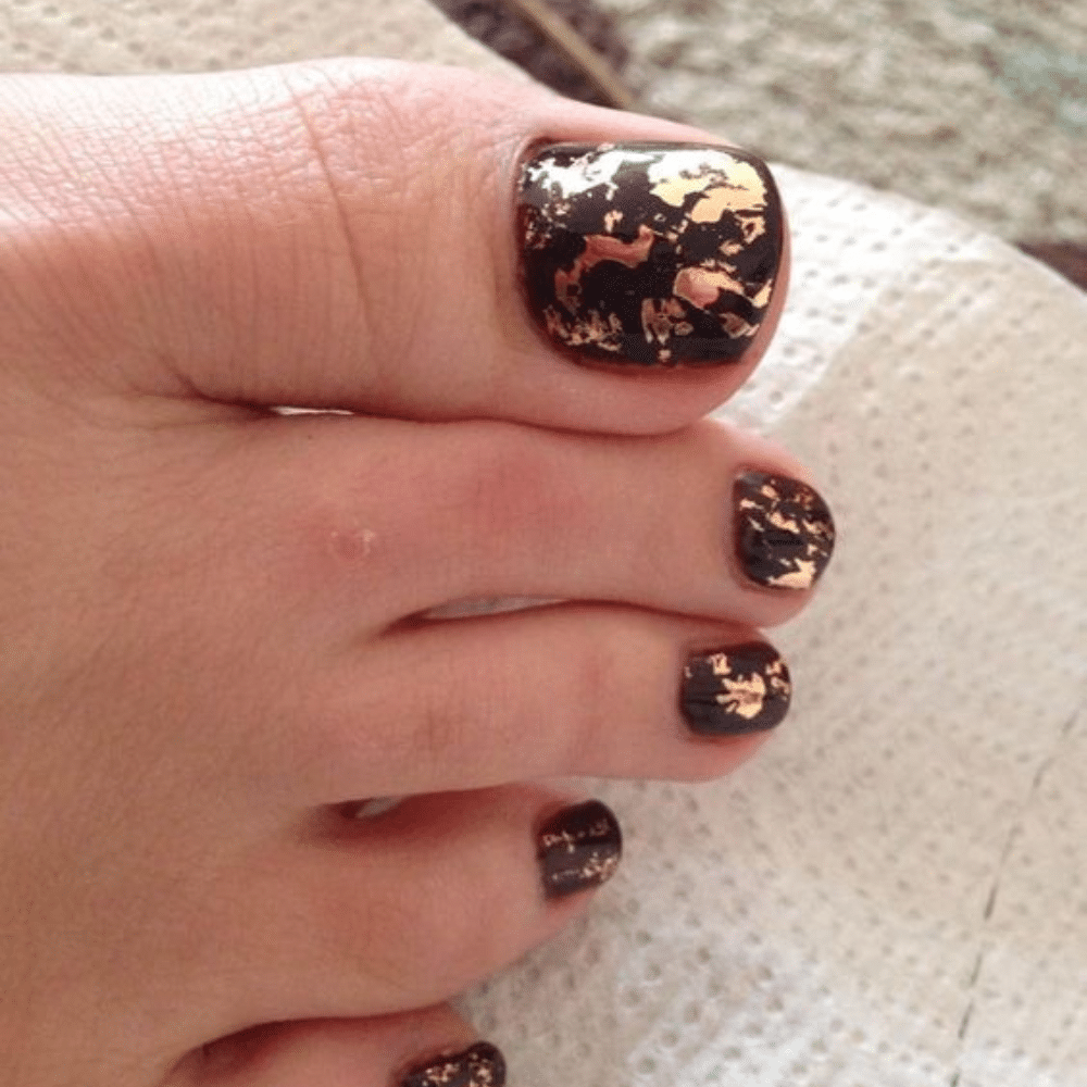 Close-up of toes with Gold Leaf Luxury toe nail