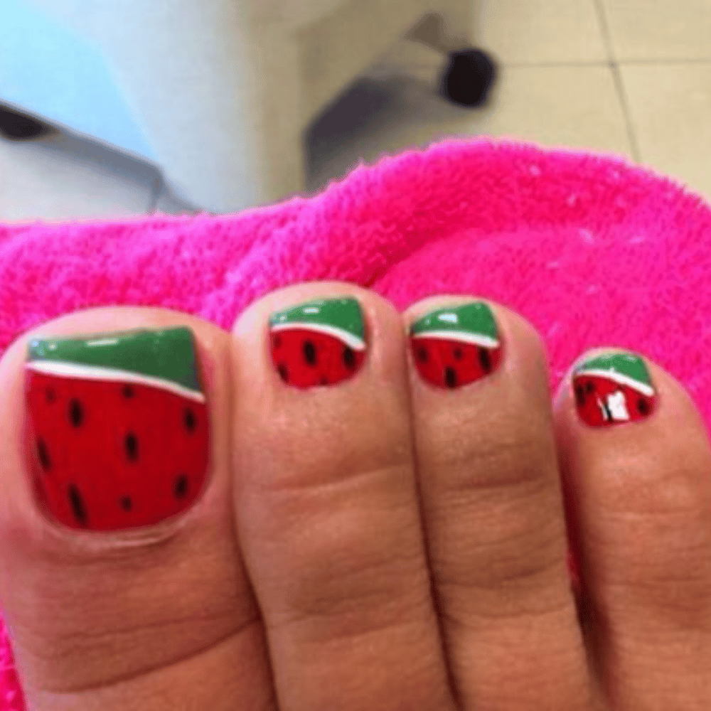 Close-up of toes with watermelon designed toe nail