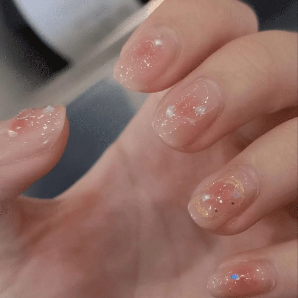 A person showcasing their manicured pink and white nails, highlighting the elegant design and vibrant colors.