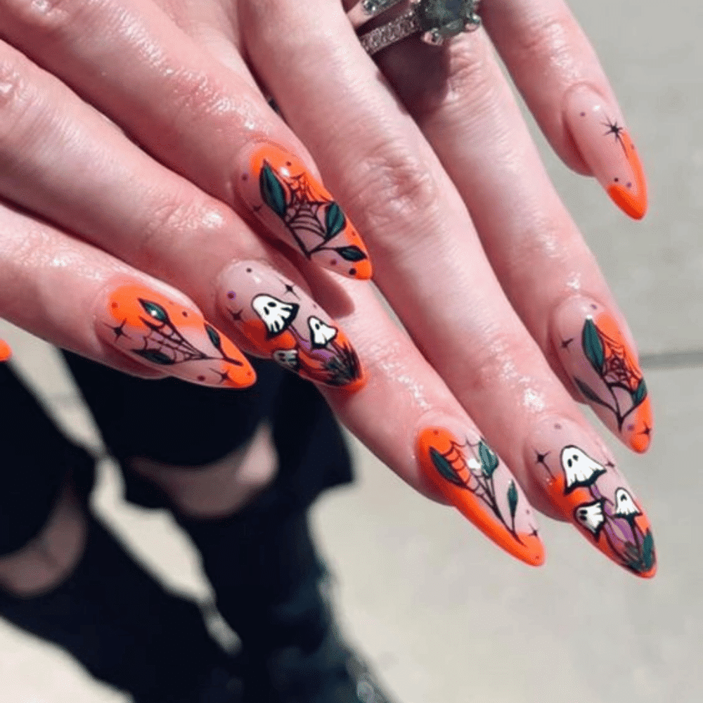 Hands with long, almond-shaped nails featuring intricate Halloween-themed designs with spider webs, ghosts, leaves, and stars.