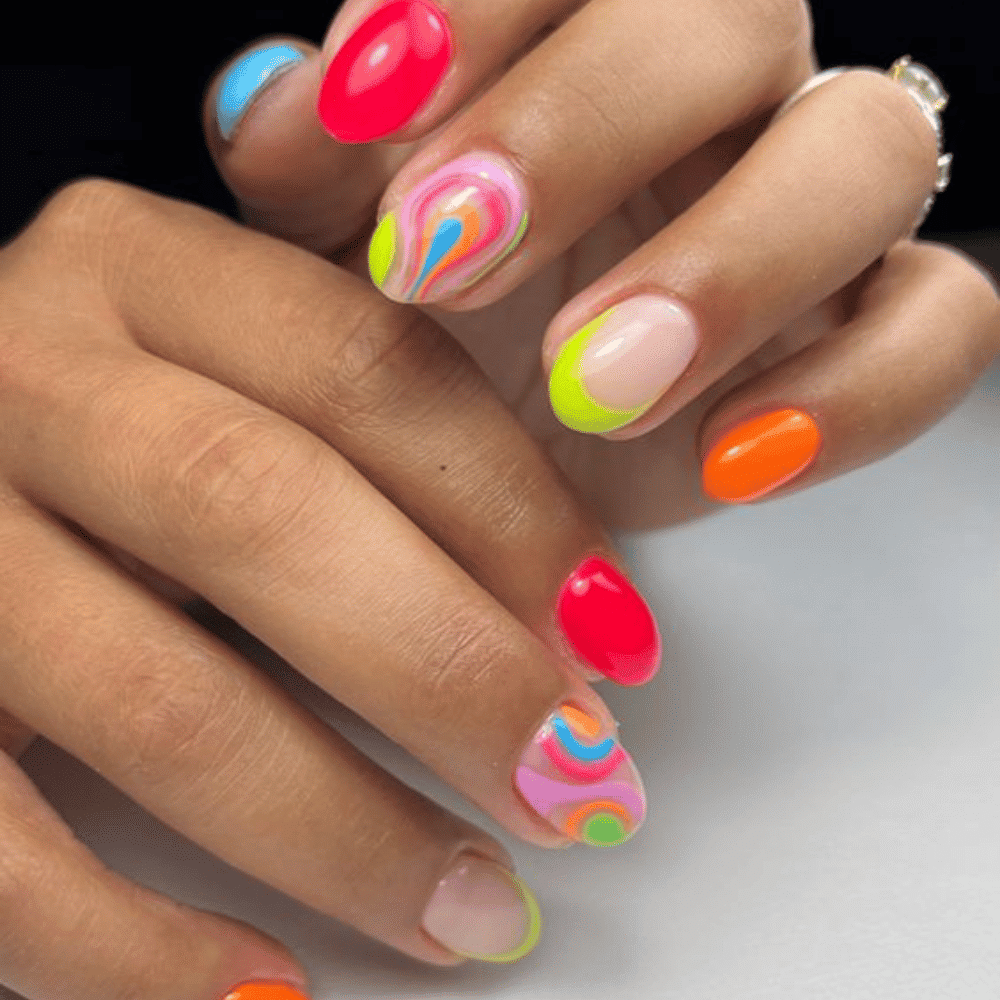 A woman displays her colorful manicured nails adorned with vibrant designs, showcasing creativity and style.