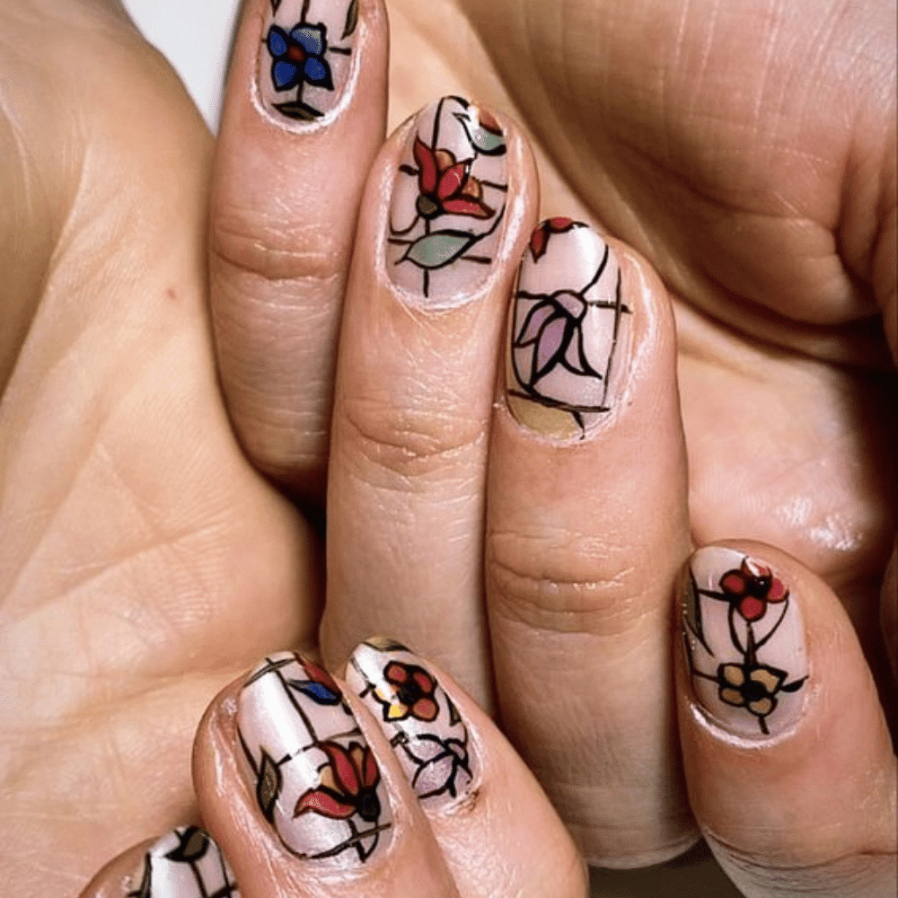 A woman showcasing her hands adorned with vibrant and artistic nail designs, highlighting creativity and style.