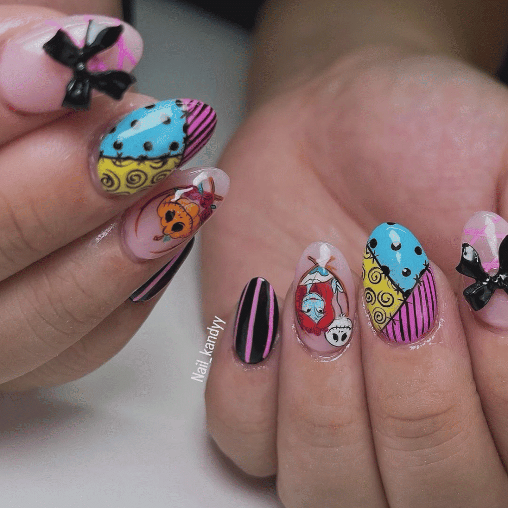 Close-up of a person's hands with intricately decorated nails inspired by "The Nightmare Before Christmas," featuring characters and patterns from the film.