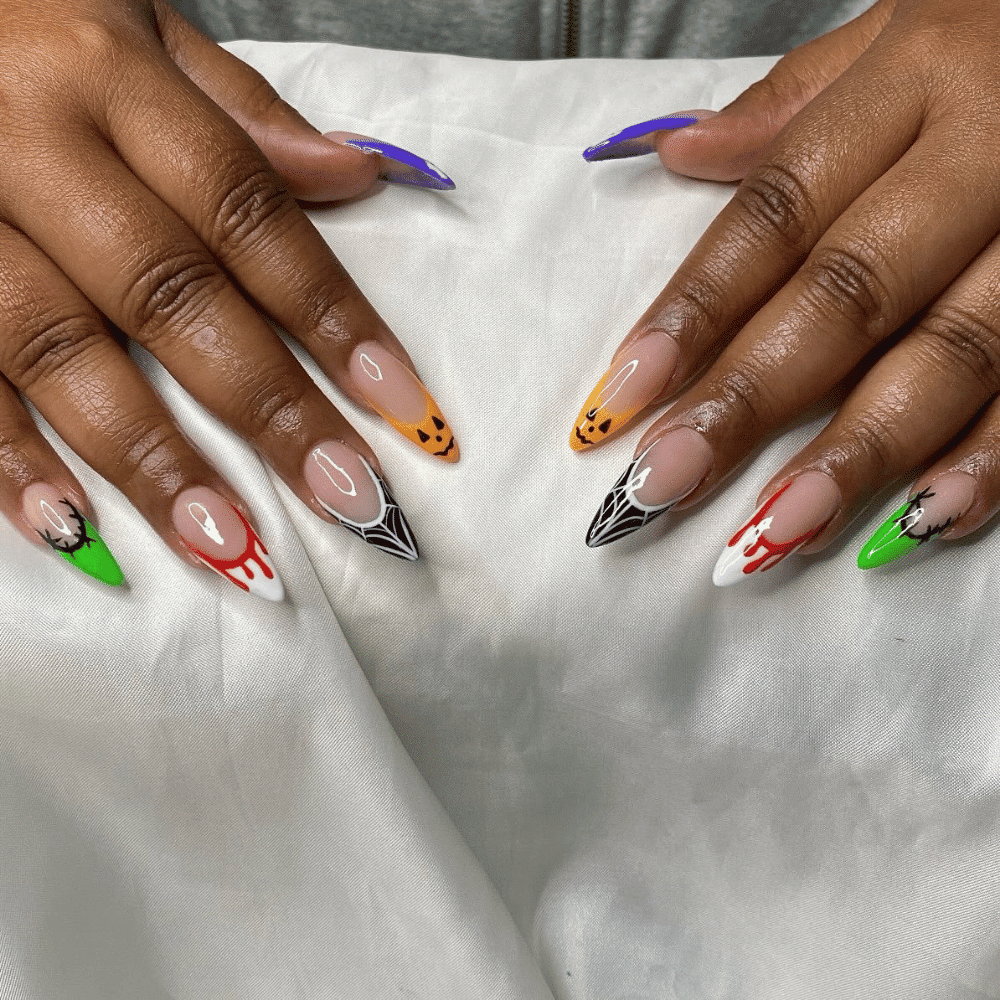 Hands with Halloween-themed nail art featuring pumpkins, spider webs, blood drips, and Frankenstein stitches.