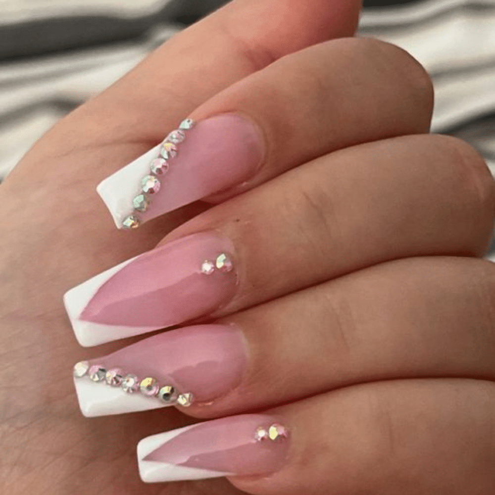 Close-up of a hand with white French tip jewel encrusted nail