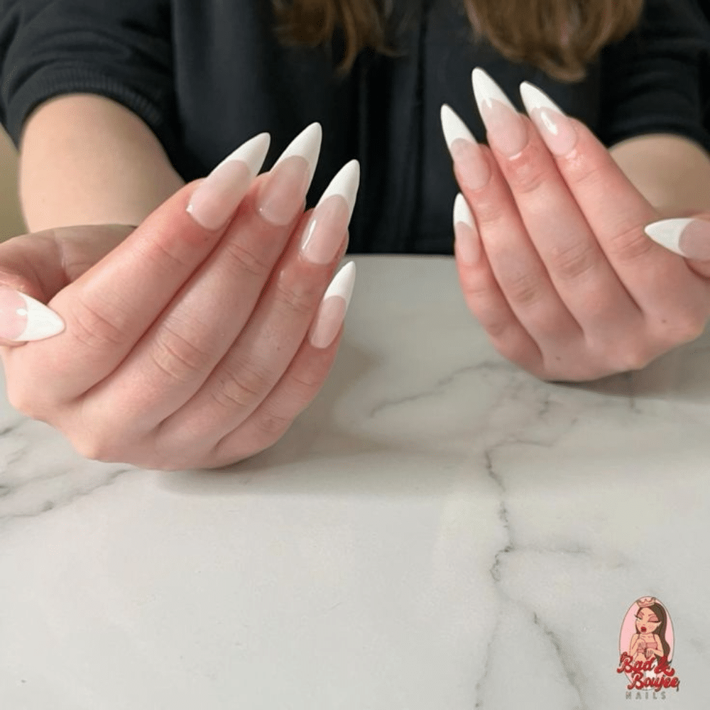 Close-up of a hand with white French tip stiletto french nail