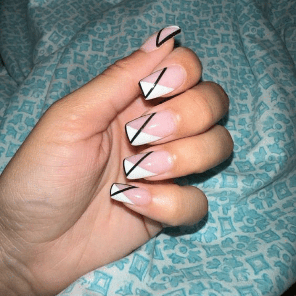 Close-up of a hand with white French tip nail with geometric patterns