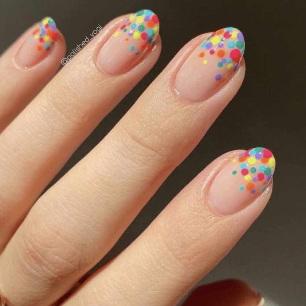 Close-up of a hand with white French tip polka dotted nail