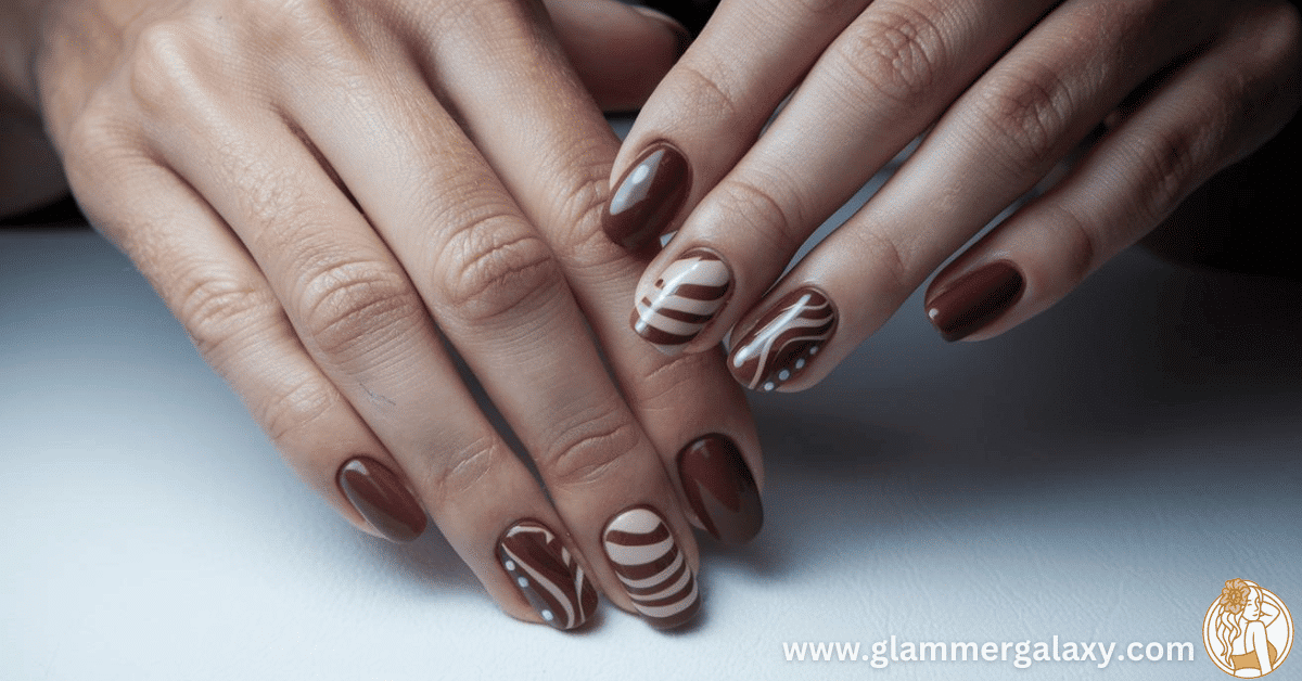 Two hands with brown and white striped nail art displayed against a light background.